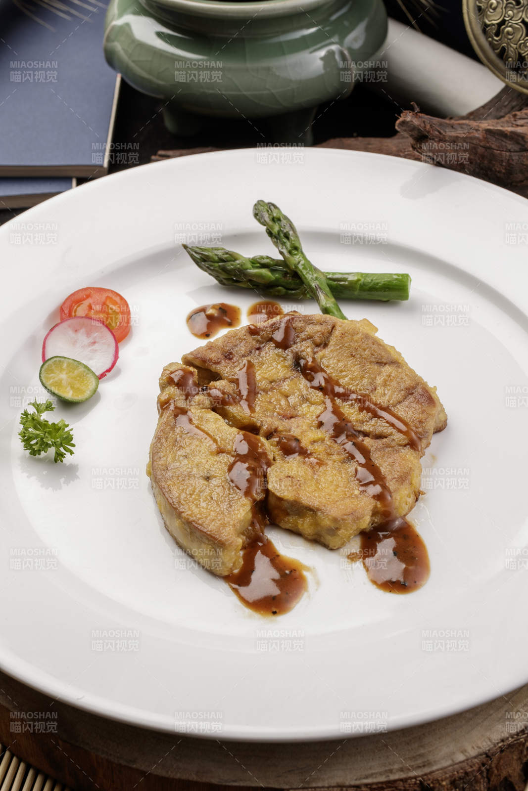 白色圆形瓷盘装的香煎法式鹅肝摆放在樟木砧板上图片