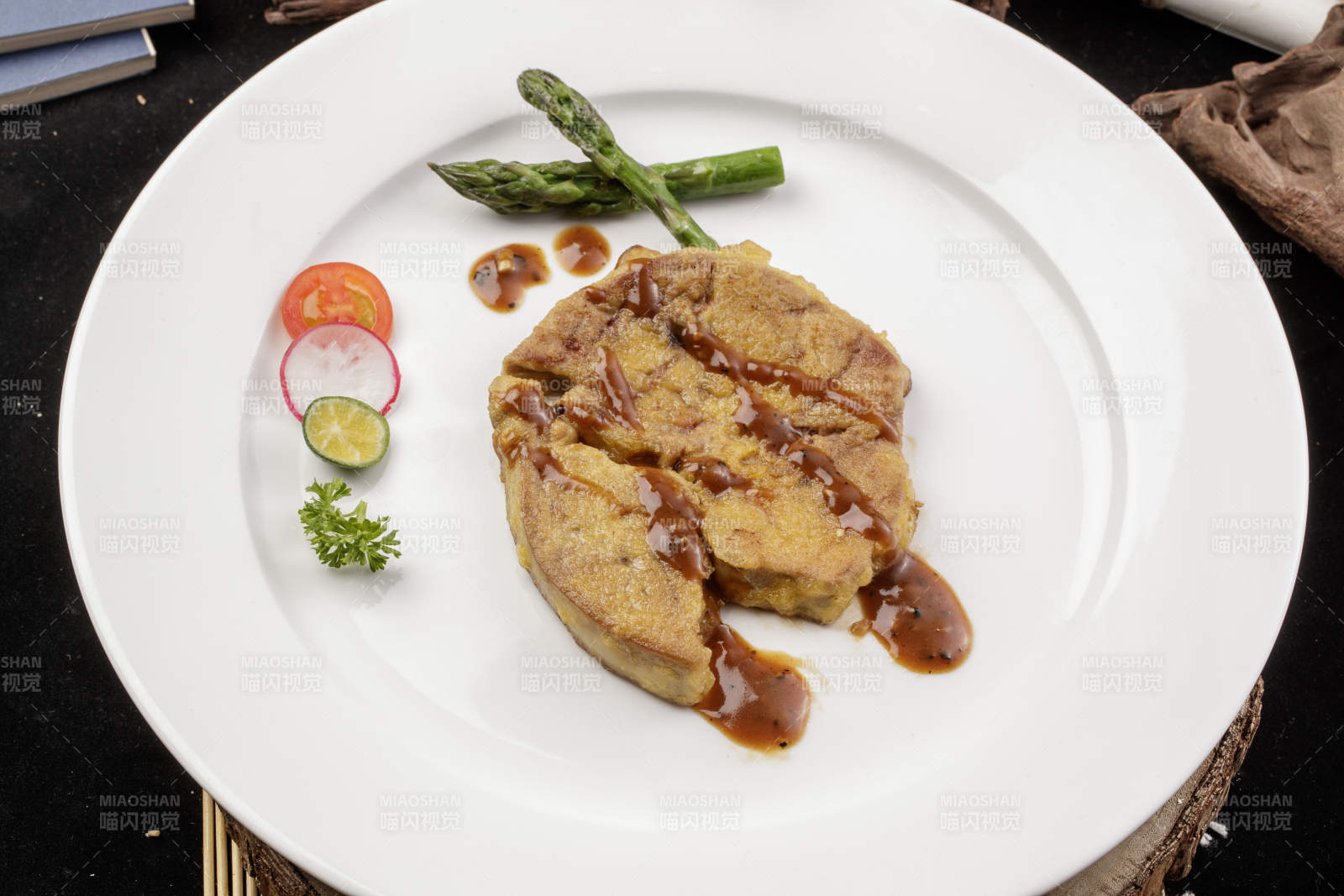 白色圆形瓷盘装的香煎法式鹅肝摆放在樟木砧板上图片