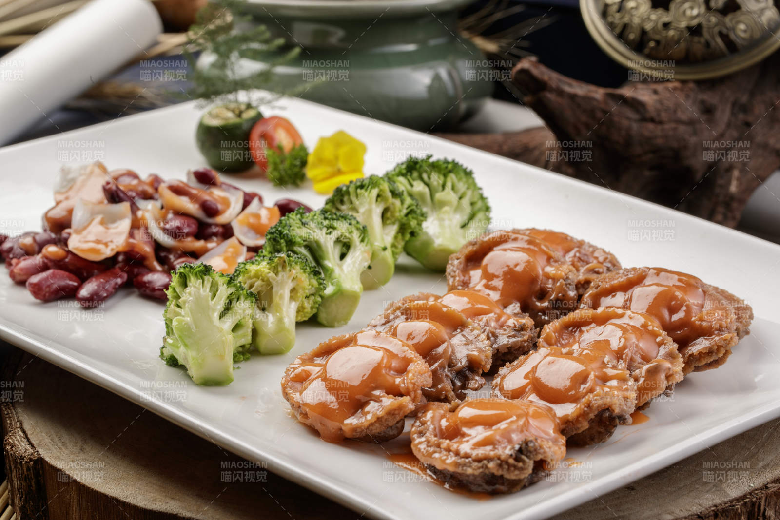 长方形瓷盘装的百合红豆浓汁薏米鲜鲍鱼摆放在樟木砧板上图片