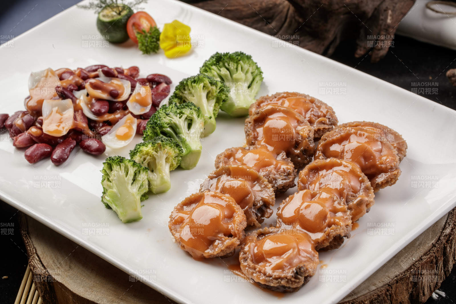 长方形瓷盘装的百合红豆浓汁薏米鲜鲍鱼摆放在樟木砧板上图片