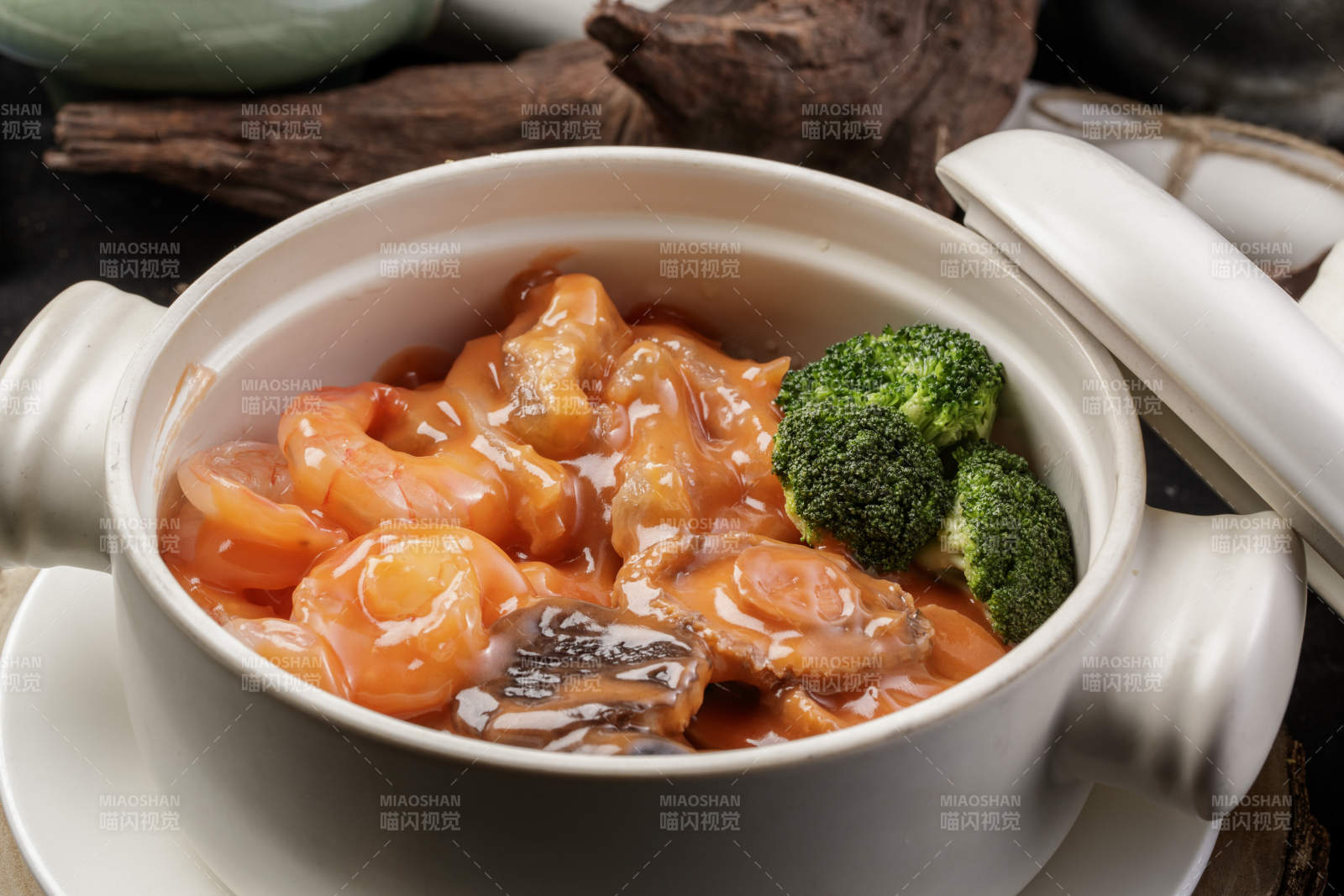 白色瓷砂锅装的浓汤海鲜煲摆放在寿司帘图片