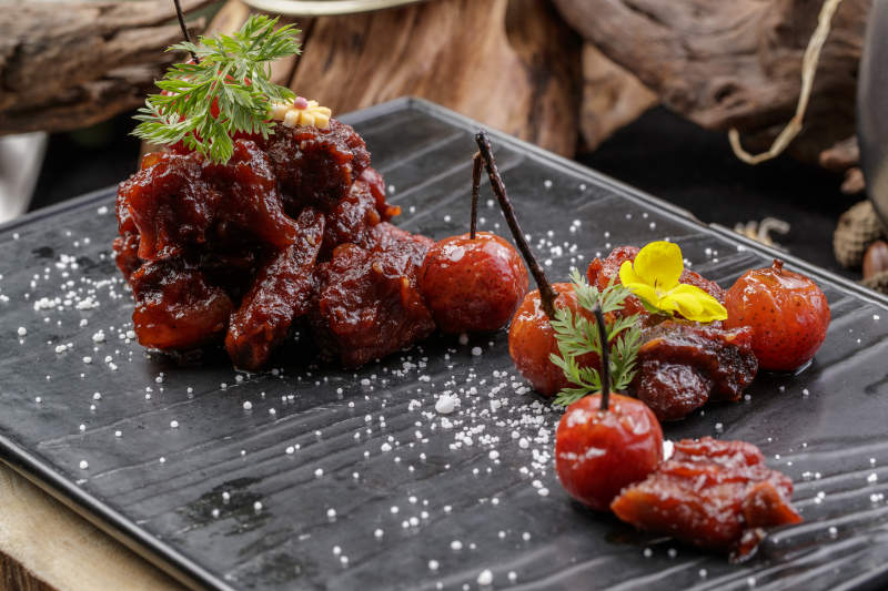 黑色石板装的山楂牛肉摆放在寿司帘上图片