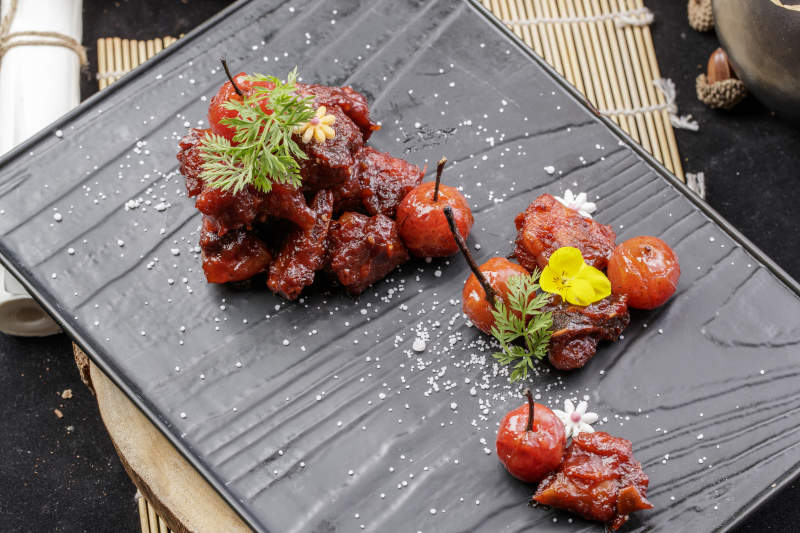 黑色石板装的山楂牛肉摆放在寿司帘上图片