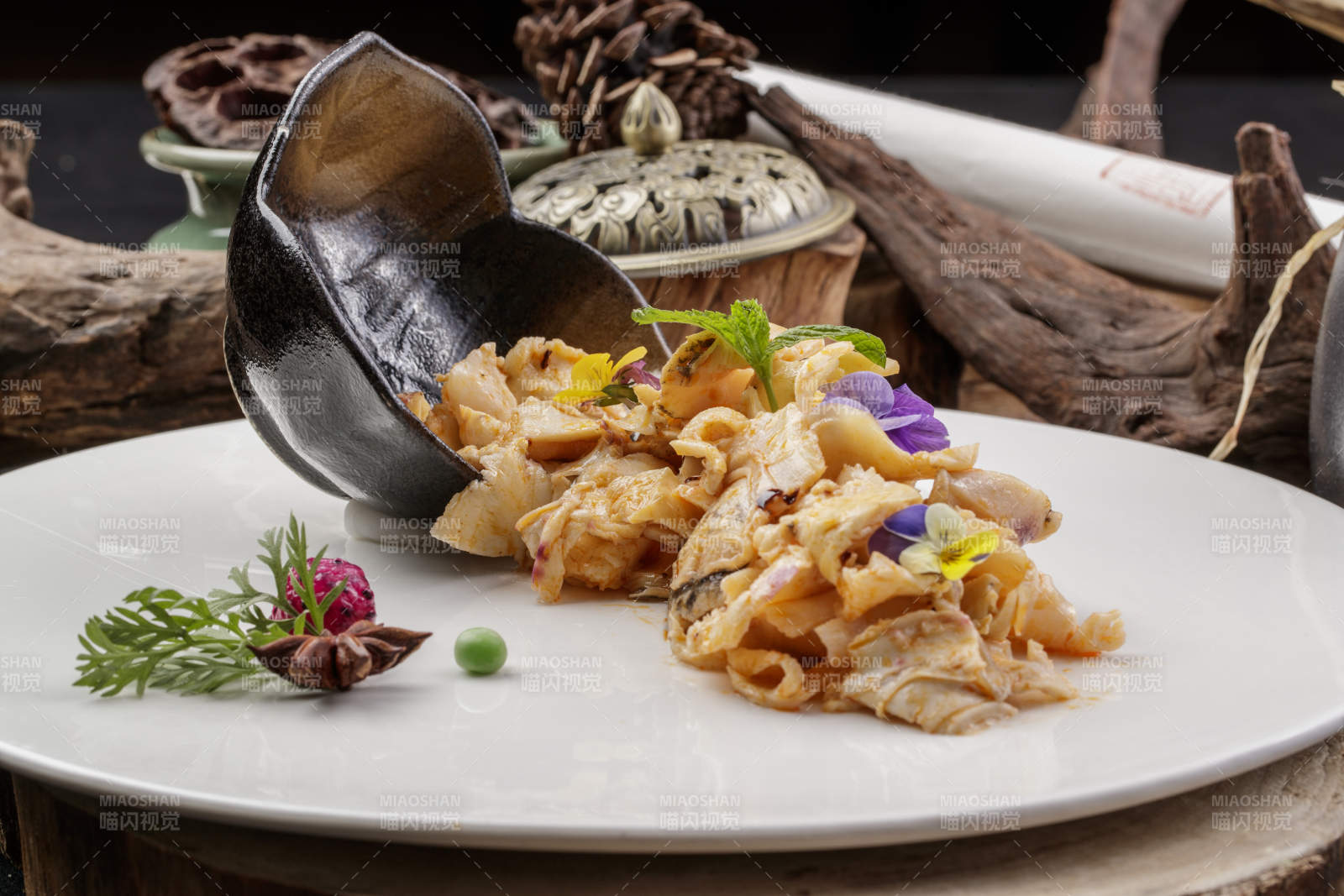 圆形瓷盘装的温拌海螺片摆放在寿司帘上图片