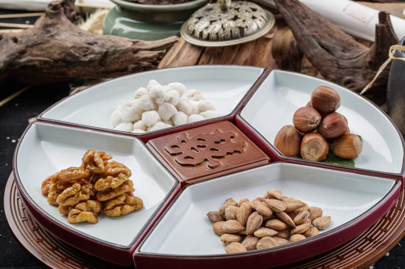 婚宴婚礼用坚果干果蜜饯小凉菜摆放在黑色背景上图片