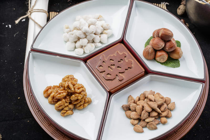 婚宴婚礼用坚果干果蜜饯小凉菜摆放在黑色背景上图片