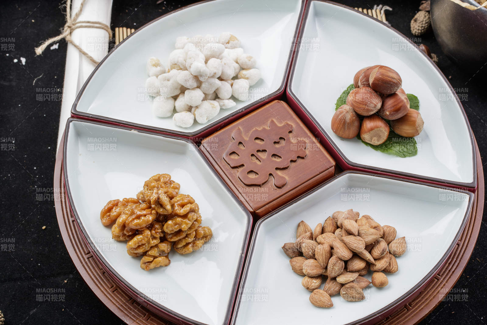 婚宴婚礼用坚果干果蜜饯小凉菜摆放在黑色背景上图片