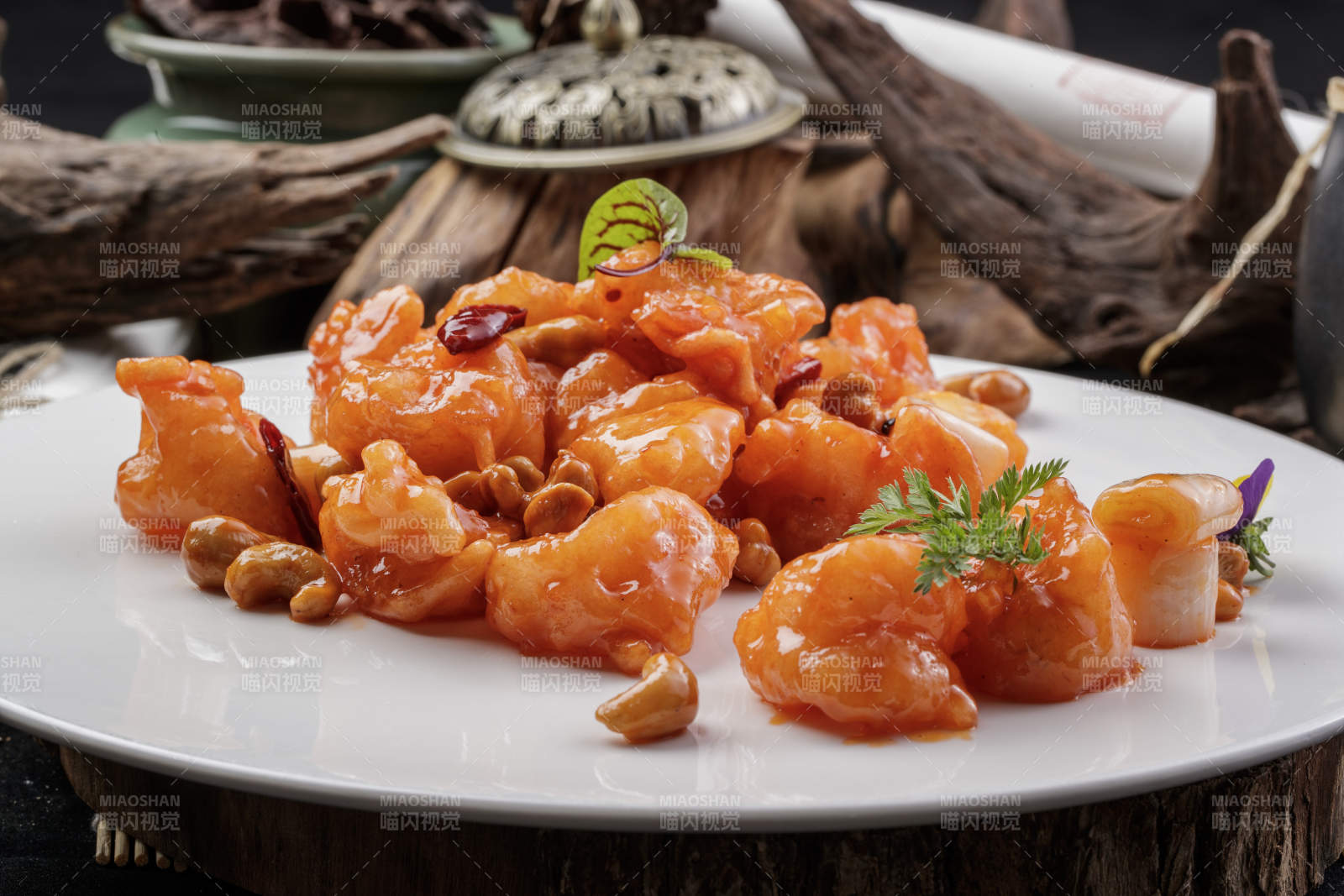 白色圆盘装的宫保大虾球摆放在寿司帘上图片