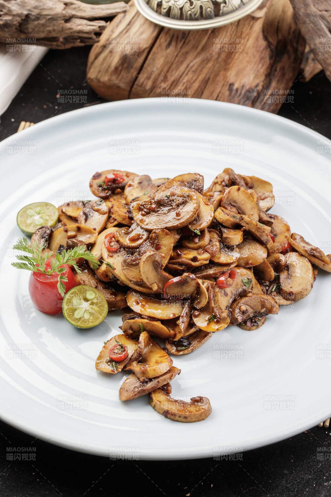 青瓷盘装的川味酱爆鲜口蘑摆放在寿司帘上图片