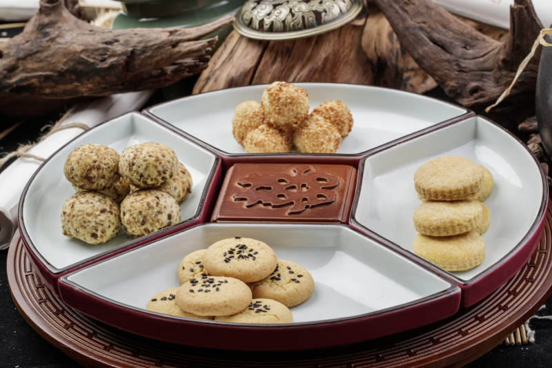 象征着喜庆祥和的婚宴点心摆放在黑色背景上图片