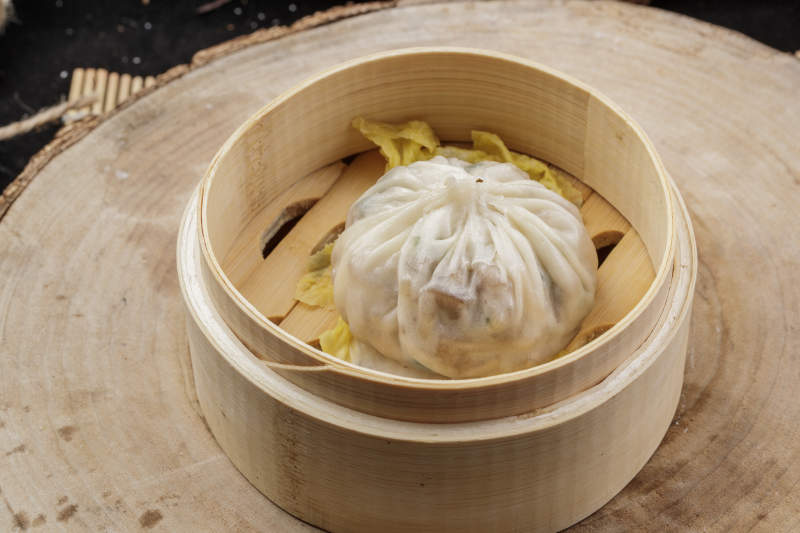 薄皮馅大的酱肉大汤包摆放在樟木砧板上图片