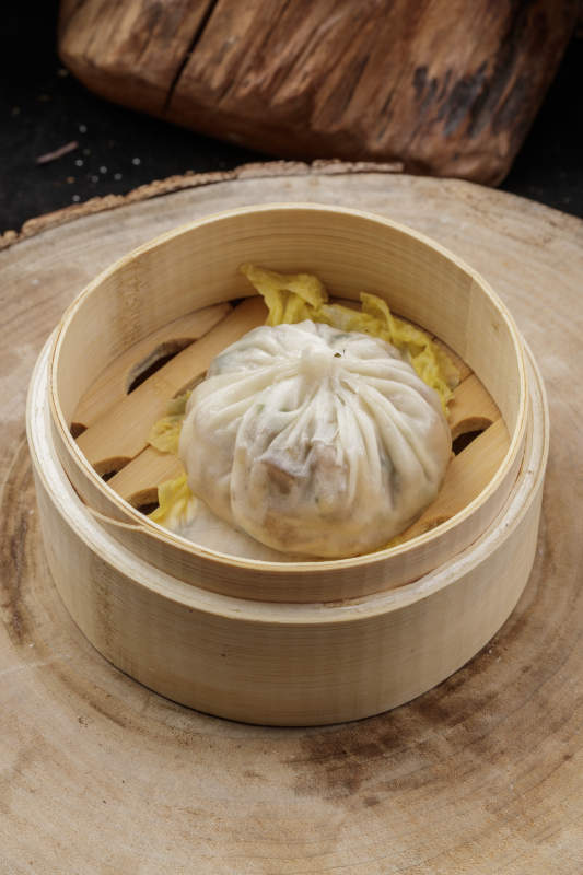 薄皮馅大的酱肉大汤包摆放在樟木砧板上图片