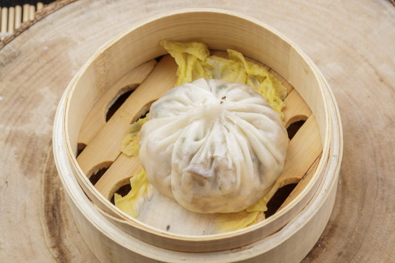 薄皮馅大的酱肉大汤包摆放在樟木砧板上图片