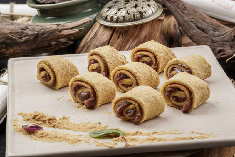 京城名小吃豆沙驴打滚摆放在寿司帘上图片