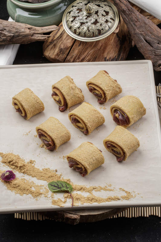 京城名小吃豆沙驴打滚摆放在寿司帘上图片