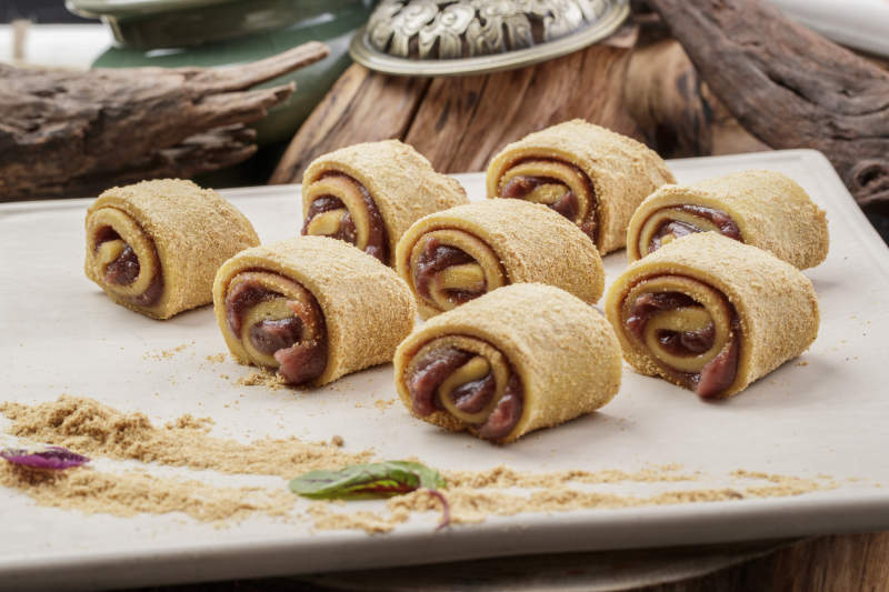 京城名小吃豆沙驴打滚摆放在寿司帘上图片