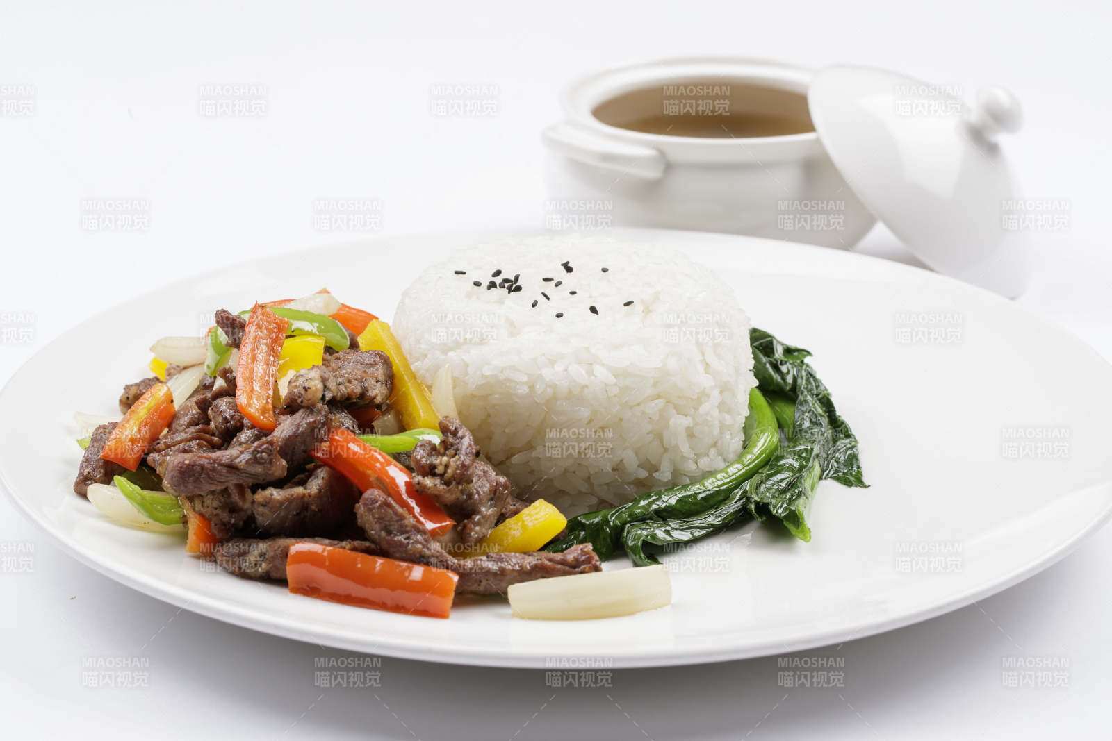 白色瓷盘装的杭椒彩椒牛柳盖饭图片