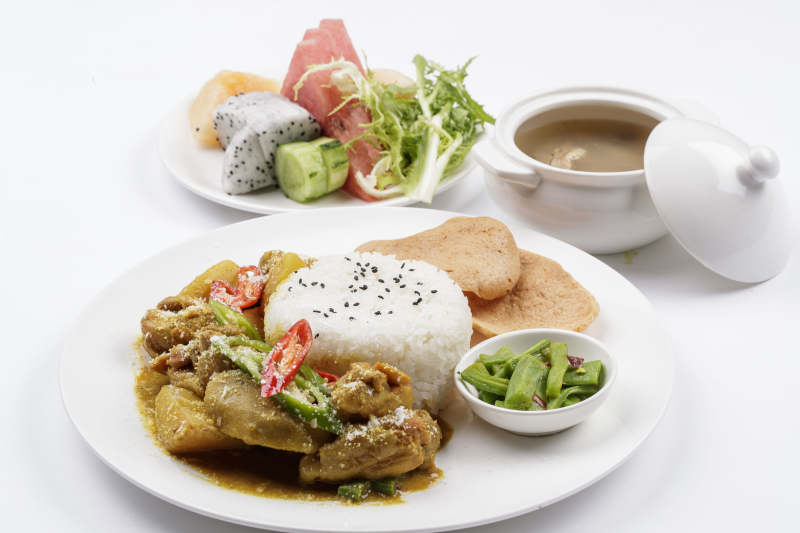 白色瓷盘装的美味咖喱鸡块盖饭图片