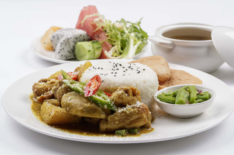 白色瓷盘装的美味咖喱鸡块盖饭图片