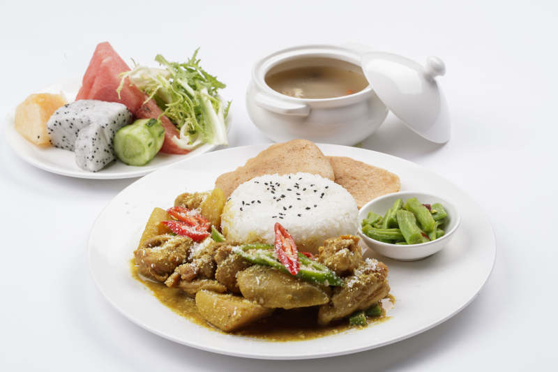 白色瓷盘装的美味咖喱鸡块盖饭图片