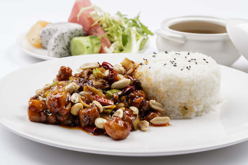 白色瓷盘装的宫保鸡丁盖饭图片