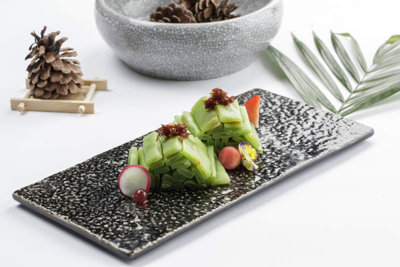 白色瓷盘装的盐水贡菜图片