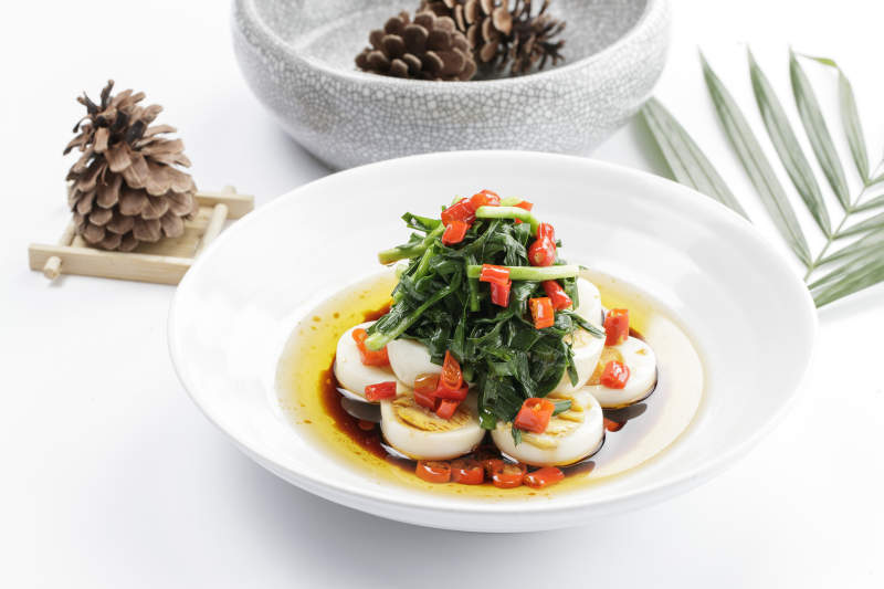 白色瓷盘装的菠菜水煮蛋图片