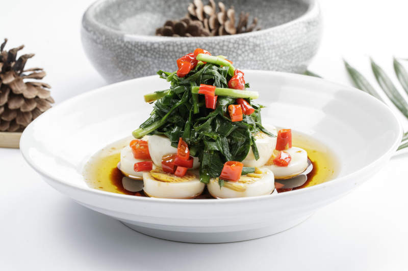 白色瓷盘装的菠菜水煮蛋图片