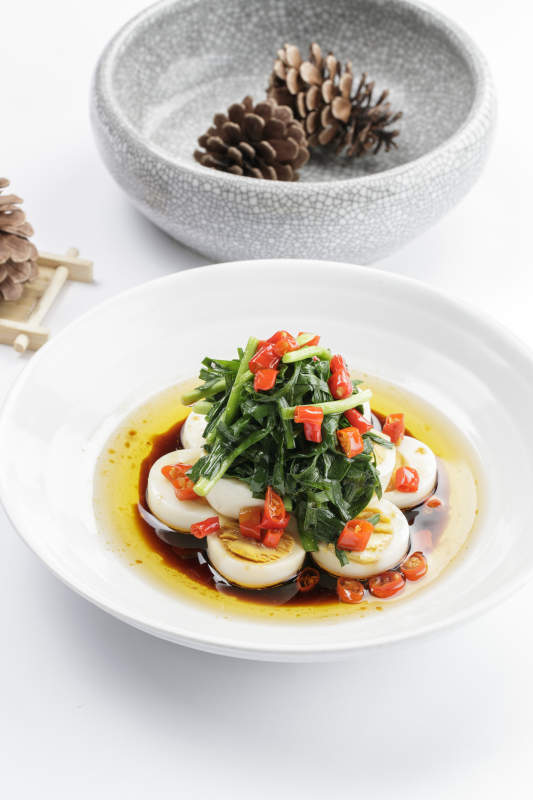 白色瓷盘装的菠菜水煮蛋图片