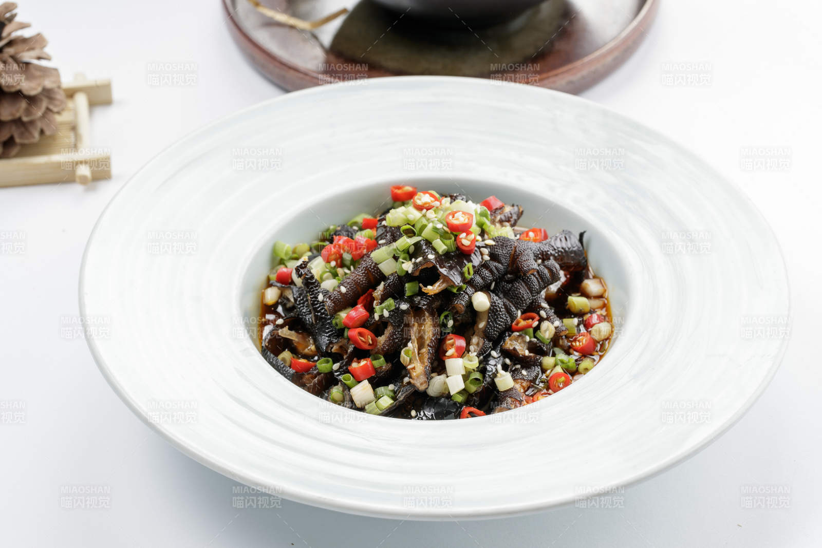 白色瓷盘装的米椒蒜香乌鸡脚图片