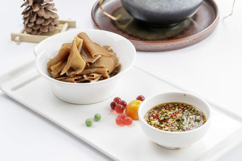 白色瓷盘装的蘸汁毛肚图片