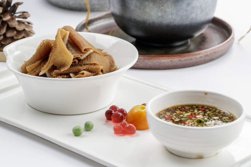 白色瓷盘装的蘸汁毛肚图片