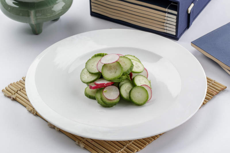 白色瓷盘装的乳瓜水萝卜图片