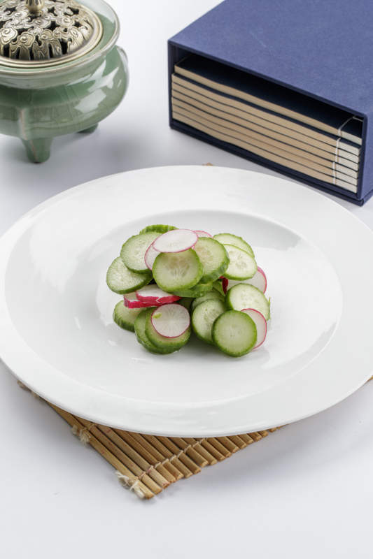 白色瓷盘装的乳瓜水萝卜图片