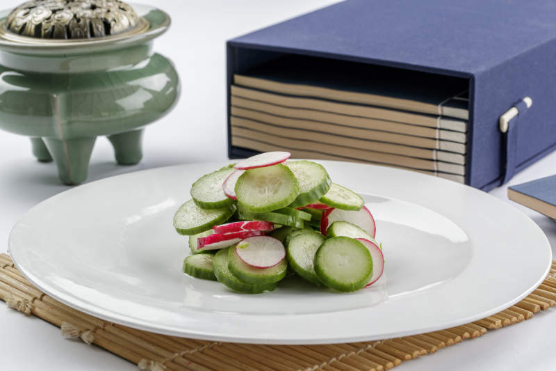 白色瓷盘装的乳瓜水萝卜图片