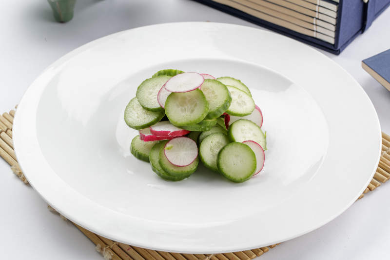 白色瓷盘装的乳瓜水萝卜图片