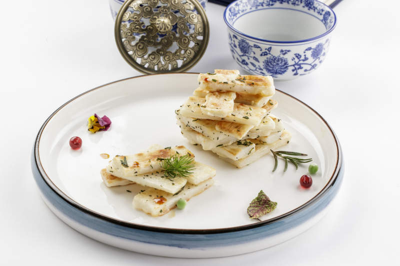 白色瓷盘装的香草煎山药图片