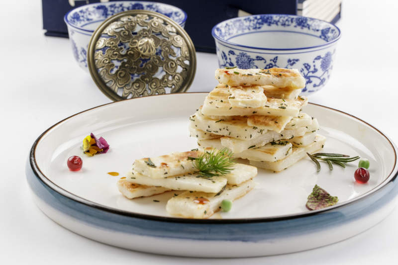 白色瓷盘装的香草煎山药图片