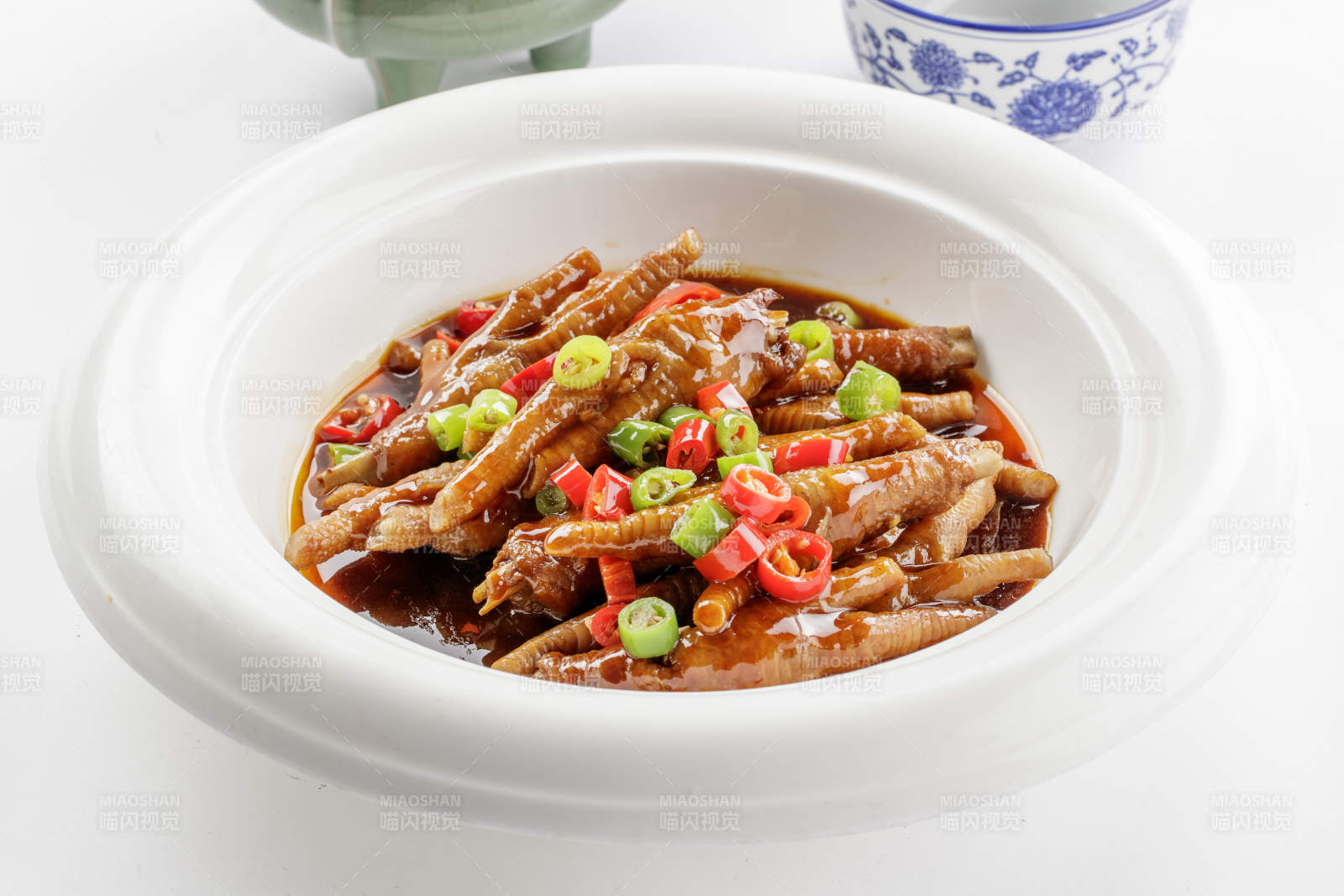 白色瓷盘装的米椒卤味凤爪图片