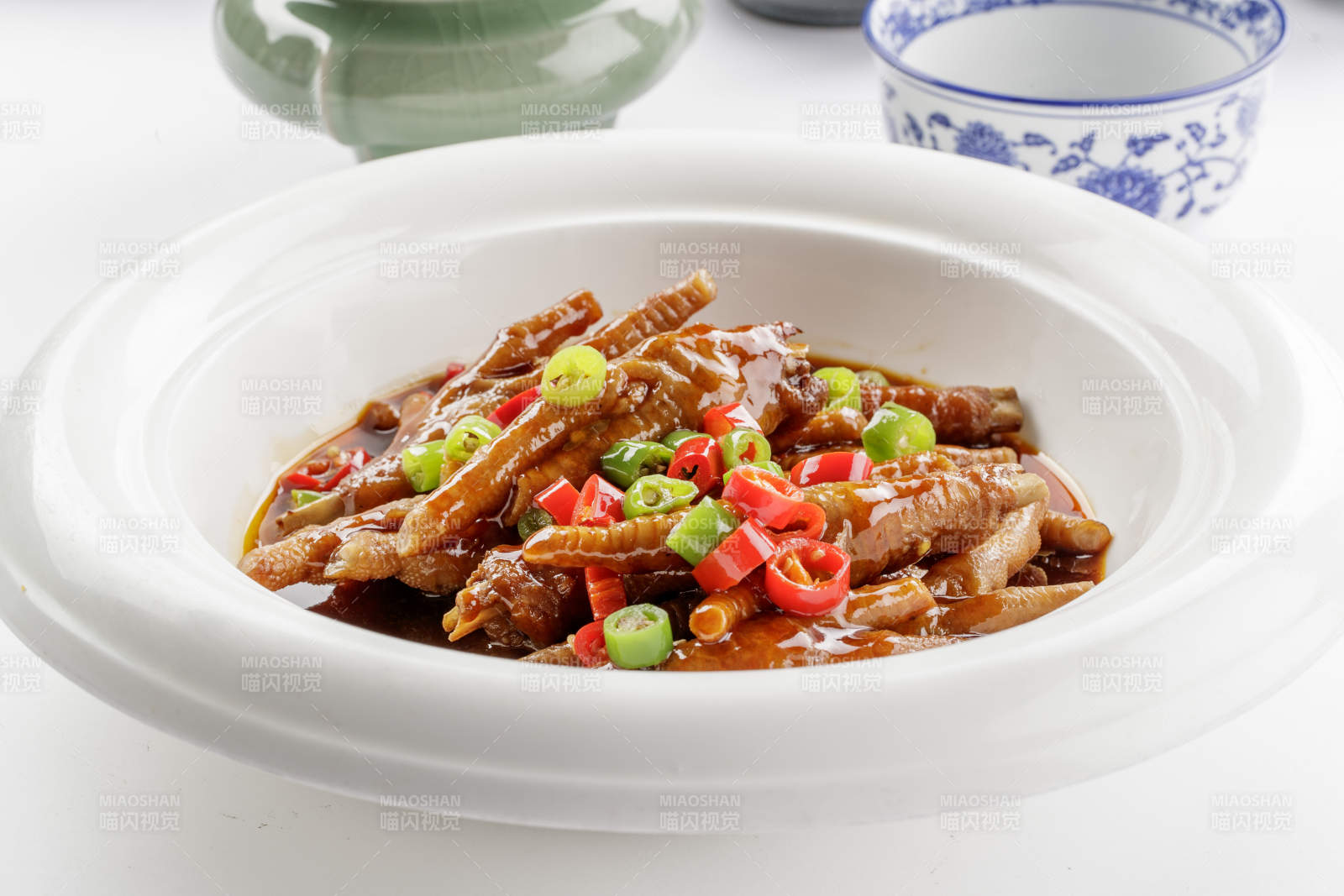 白色瓷盘装的米椒卤味凤爪图片