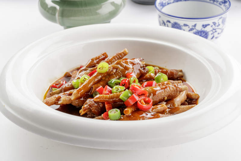 白色瓷盘装的米椒卤味凤爪图片