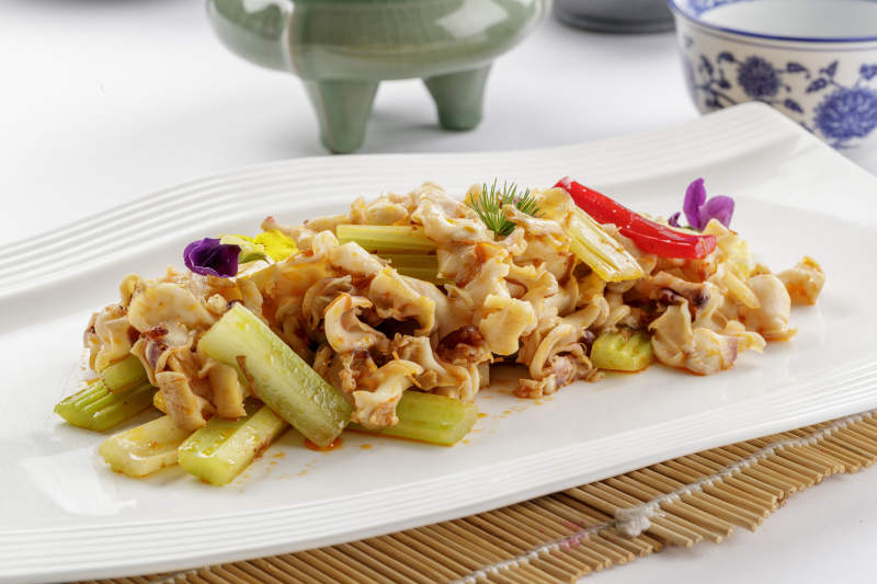 白色瓷盘装的西芹炒螺头图片