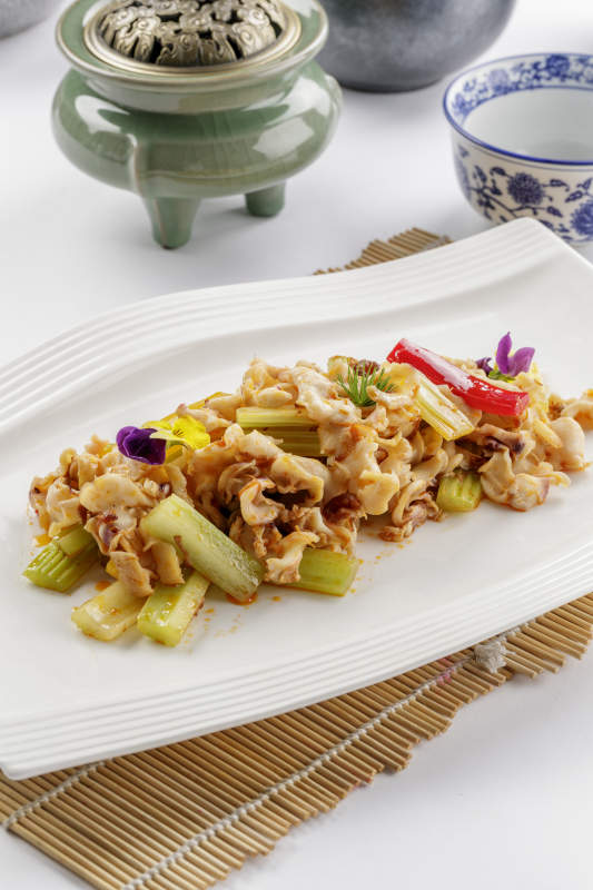 白色瓷盘装的西芹炒螺头图片