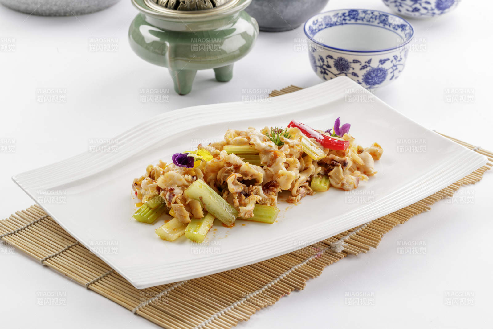 白色瓷盘装的西芹炒螺头图片