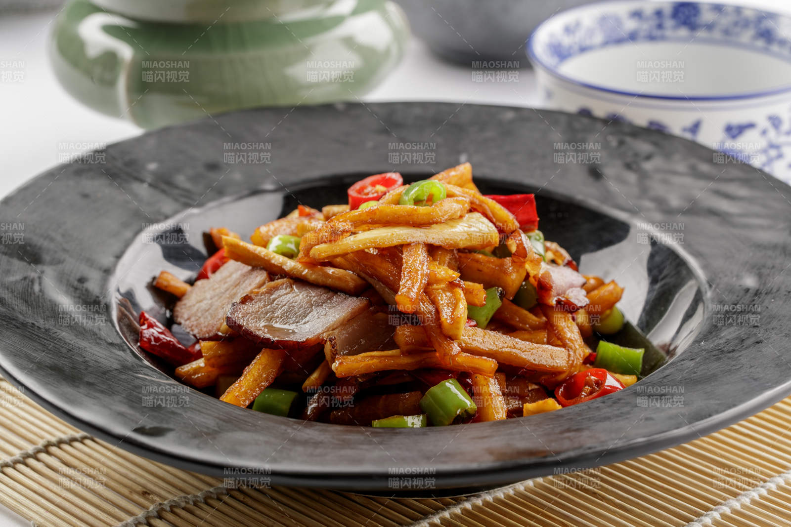 黑色石盘装的菜菔炒腊肉图片