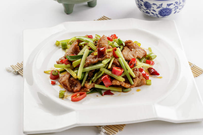 白色瓷盘装的西芹小炒黄牛肉图片