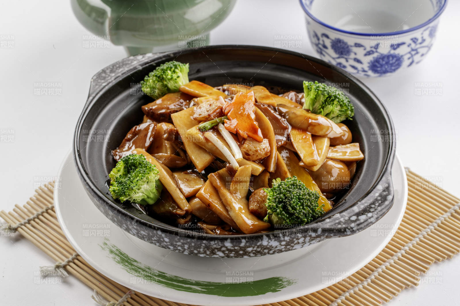 黑色砂锅装的鲍汁煲杂菌图片