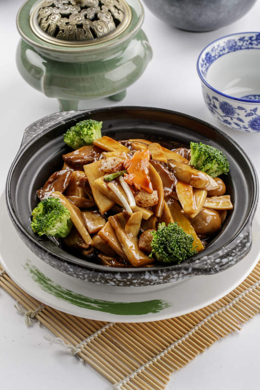 黑色砂锅装的鲍汁煲杂菌图片