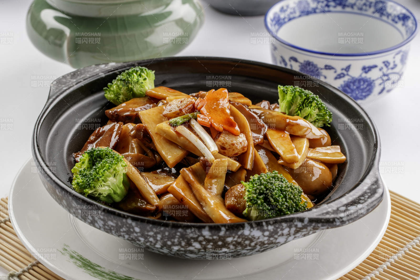 黑色砂锅装的鲍汁煲杂菌图片