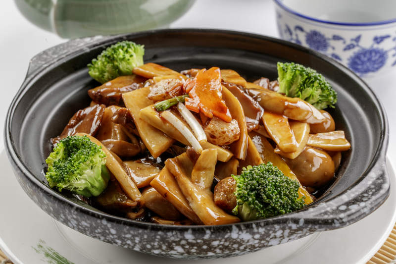 黑色砂锅装的鲍汁煲杂菌图片